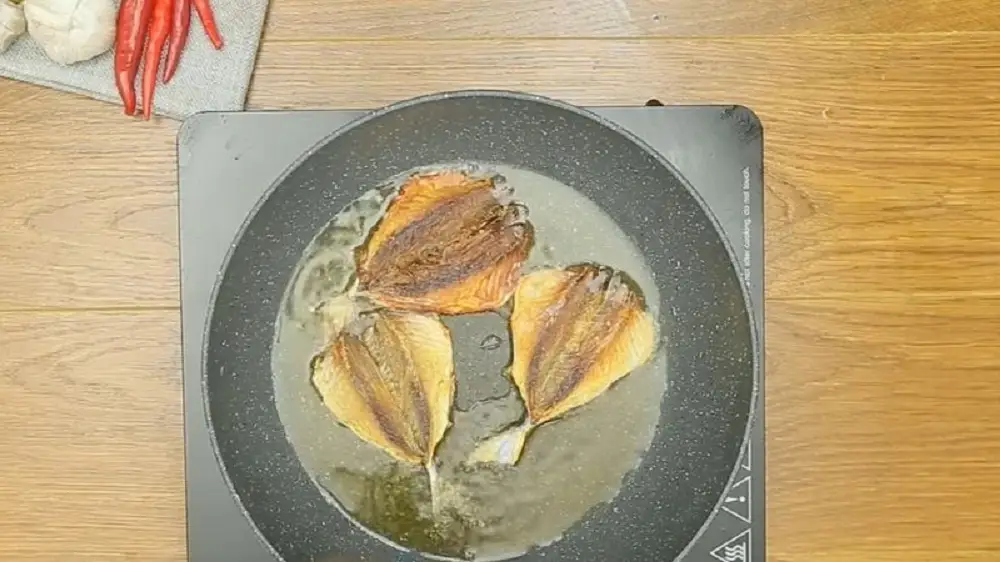 Chiên cá chỉ vàng khô ở lửa vừa để cá vàng thơm và không bị cháy