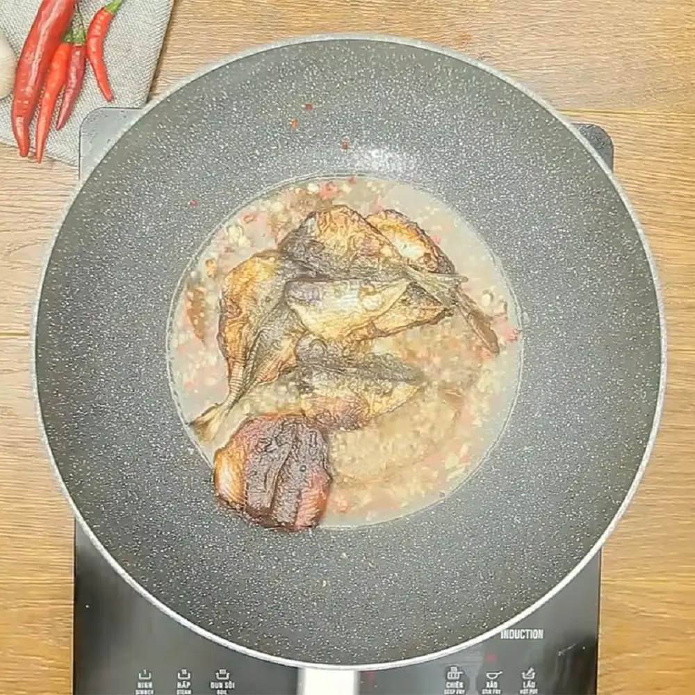 Rim cá chỉ vàng khô với lửa nhỏ để sốt me thấm đều vào thân cá